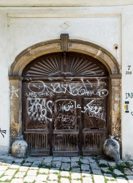 Old dark brown painted with graffitti gates — Stock Photo, Image