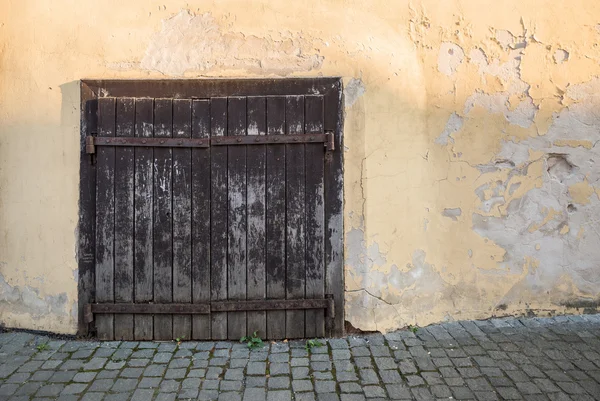 Portas de madeira velhas na parede amarela riscada — Fotografia de Stock