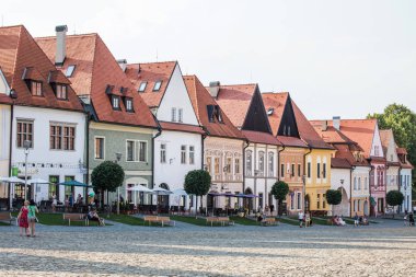 Bardejov, Slovakya - 09 Ağustos 2015: Turist banklar eski ana kare binalar sadow içinde oturmak. Çoğunlukla Rönesans, başlangıçta Gotik. Bardejov, Slovakya