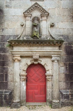 Eski kırmızı kapı ve scultpure kutsal adam. 