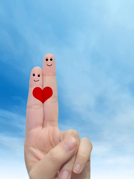 female fingers painted with heart and faces