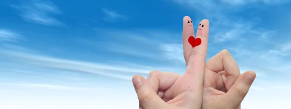 female fingers painted with heart and faces