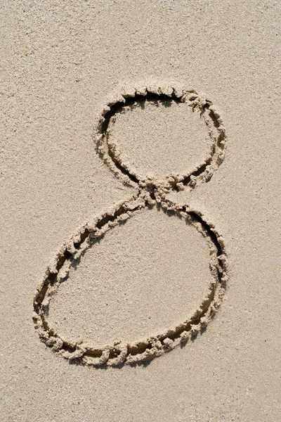 Conceito ou conceitual fonte de areia ou número esculpido na praia exótica perto do mar isolado em um fundo arenoso, metáfora para a natureza, natural, educação, caráter, tropical, tropical, tipo, mensagem ou verão — Fotografia de Stock