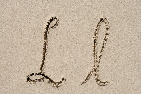 Concept or conceptual sand font or letter set group or collection carved on exotic beach near sea isolated on a sandy background, metaphor to nature, natural, education, character, message or summer — Stock Photo, Image
