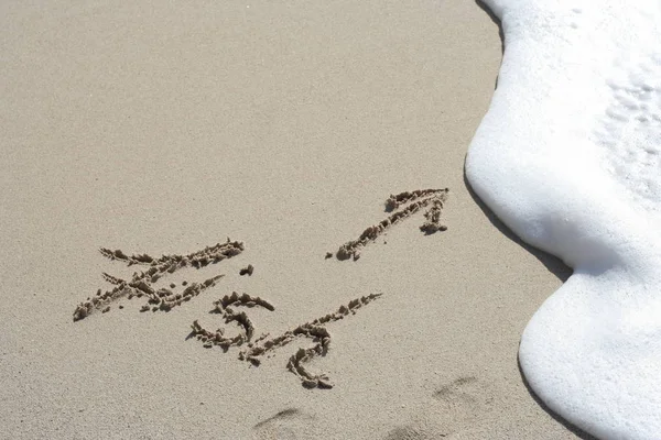 Altın kum bir beyaz dalga sıçramasına için bir plajda bir ok ile el yazısı balık — Stok fotoğraf