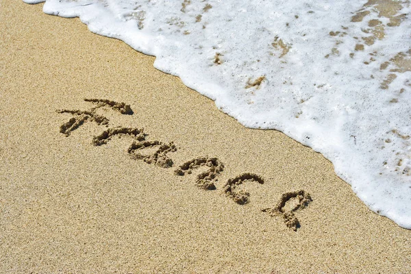 Koncept eller begreppsmässig handgjorda eller handskrivna Frankrike text i sanden på en strand i en exotisk ö — Stockfoto