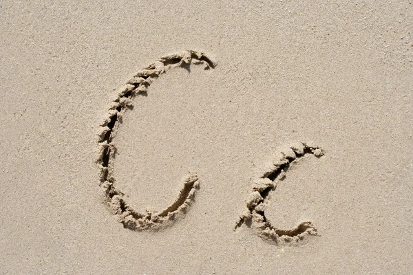 Концепція або концептуальний піщаний шрифт або група літер, вирізані на екзотичному пляжі біля моря ізольовані на піщаному фоні, метафора природі, освіта, характер, повідомлення або літо — стокове фото
