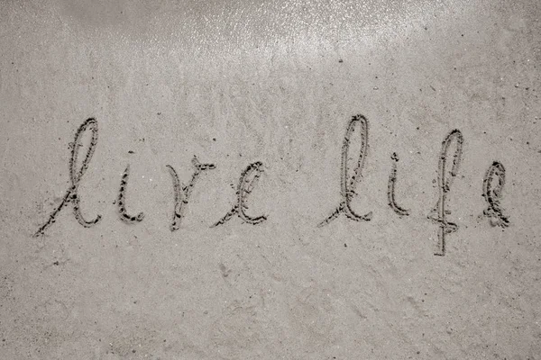 Live life handwritten in sand for natural, symbol,tourism or conceptual designs