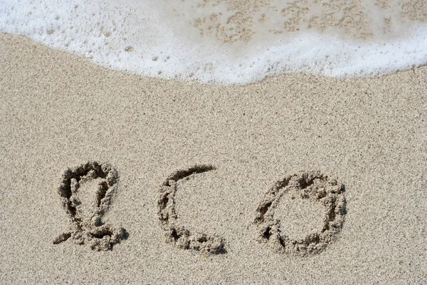 Concetto o concettuale fatto a mano o scritto a mano eco testo in sabbia su una spiaggia in un'isola esotica — Foto Stock