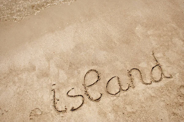 Texto de la isla tallado en una arena dorada —  Fotos de Stock