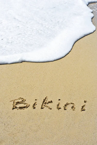 Bikini escrito a mano en arena para diseños naturales, simbólicos, turísticos o conceptuales —  Fotos de Stock