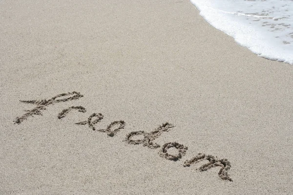 Conceptual hand drawn freedom text carved in golden sand