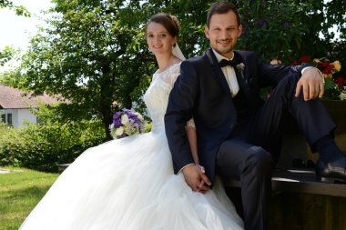 Bir parkta bir bankta oturan genç taze evli çift