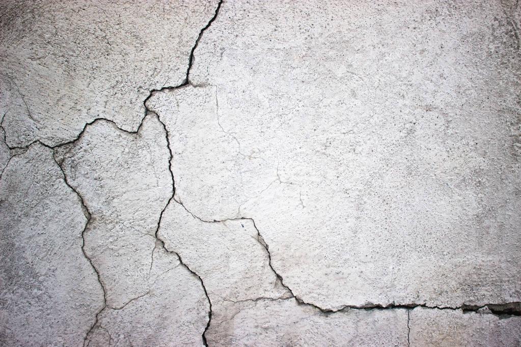 cracked concrete wall covered with gray cement surface as backgr