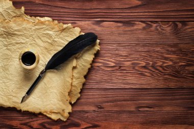 Siyah kalem ve mürekkep ahşap bir sekmede eski kağıt arka plan üzerinde