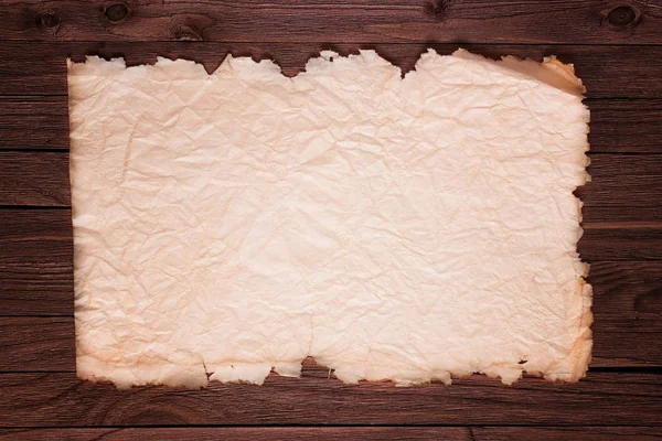 Vieja hoja horizontal rota del papel en tablero de madera marrón — Foto de Stock
