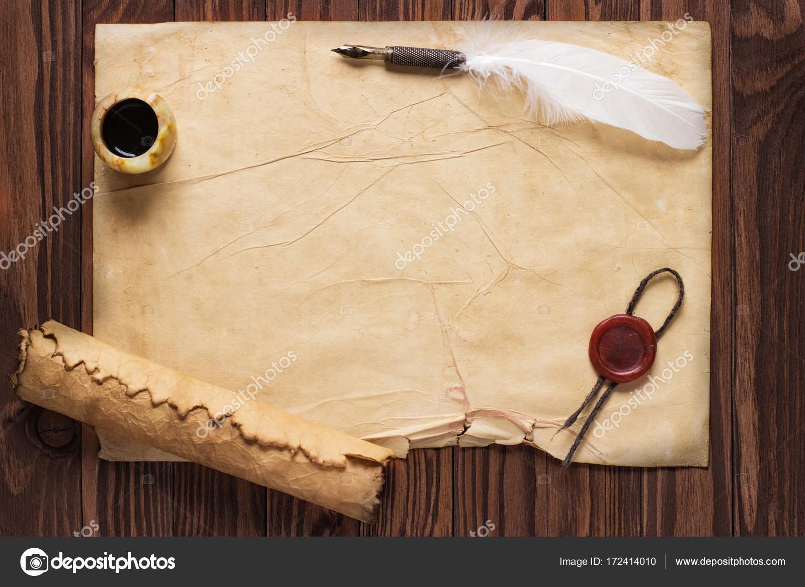 Closeup of scroll and quill near ink-pot on wooden table — Stock
