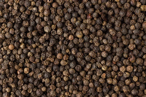 Black pepper grains spice as a background, natural seasoning tex Stock Photo