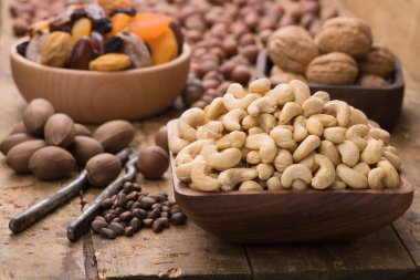 Ahşap masada kabuğundan çiğ kaju fıstığı. Vejetaryen ve vejetaryen için yararlı gıda malzemeleri..