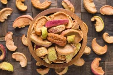 Ahşap masa arkasında kurumuş elmalar..