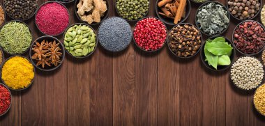 Etiketinde yer olan baharatlar ve otlar. Ahşap masada çeşitli çeşniler, üst manzara..