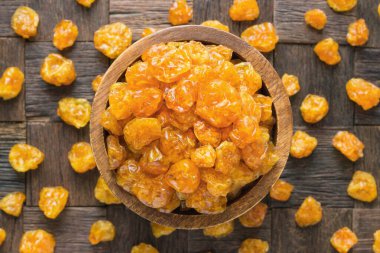 Şekerli meyve, ahşap masa arkasında şekerli kurutulmuş bitki özü..