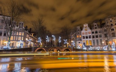 Amsterdam, December 2015: Tour boats view an artwork 'Run Beyond' in a canal on the 'Water Colors' exhibition of the Amsterdam Light Festival clipart