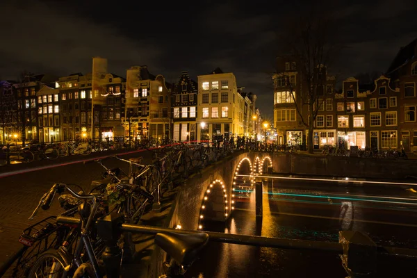 Senderos ligeros de coches y barcos en los canales de Ámsterdam — Foto de Stock