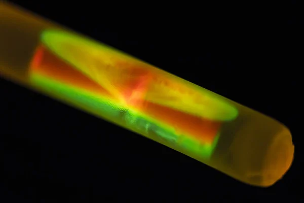 Two liquids mix in a chemiluminescent bracelet after breaking the internal glass capillary — Stock Photo, Image