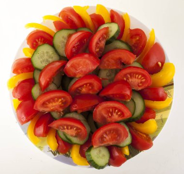 Beyaz bir arka plan üzerinde izole bir tabakta sebze dilimlenmiş