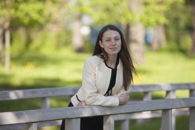 Kız bir ahşap köprü korkuluk üzerine eğilerek