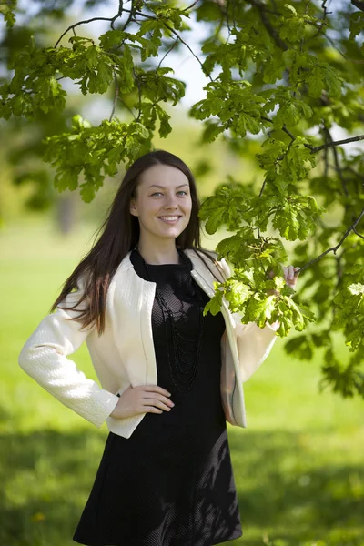 Mutlu kız parkta bir ağacın altında ayakta