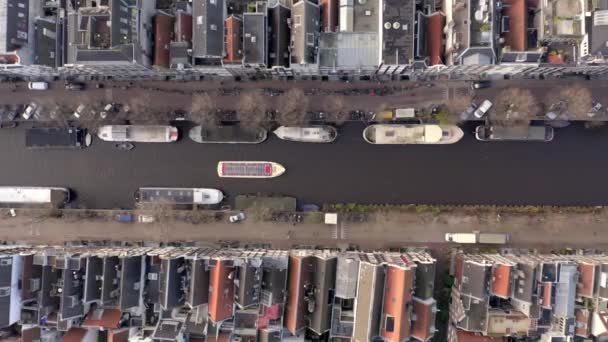 リバーサイドハウスの間でアムステルダムの運河ボートツアー鳥の目のビュー — ストック動画