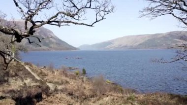 Ormanlar ve Dağlarla çevrili bir göldeki kanocular