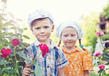 Rus erkek ve kız bahçede güller