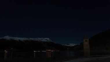 Gece - kış timelapse Resia gölden, South Tyrol, İtalya görünen Curon çan kulesi