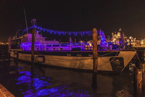 Venedik, İtalya-Ocak 02 2018: yılbaşı dekorasyonu ile tekne Basilica della Salute önünde geceleri demirli.