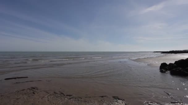 Пан на песчаном пляже, избитый спокойными волнами в летний день — стоковое видео