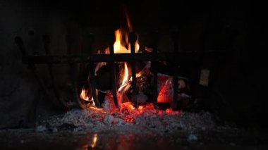 Şöminede alevler ve közler yanıyor.