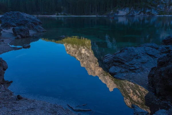 Dolomitic peaks and firs reflections on the Braies lake crystalline waters — Stock Photo, Image