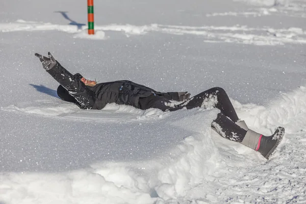 Blonde girl happy while lying on the snow — Stock Photo, Image