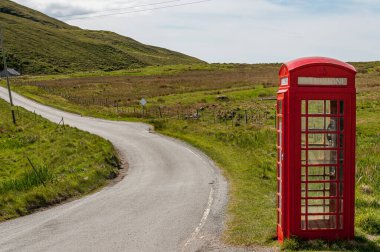 Issız bir telefon kulübesi, İskoçya 'da bir yol kenarında.