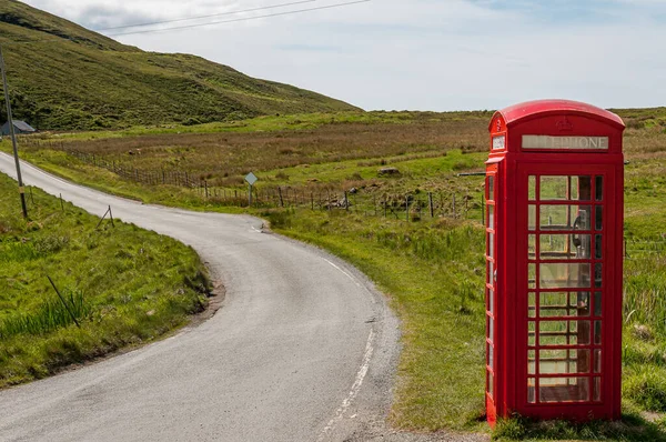 Issız bir telefon kulübesi, İskoçya 'da bir yol kenarında.