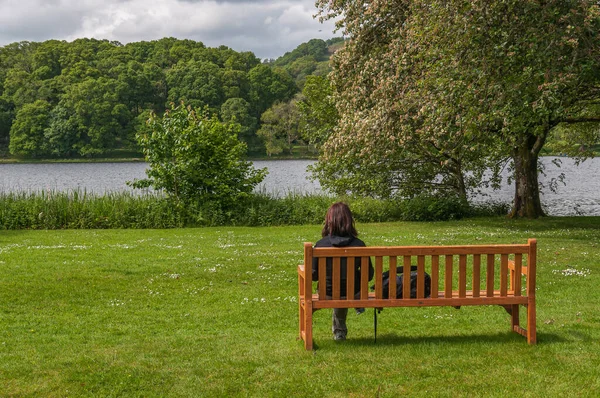 Mentheit Gölü manzarasını düşünürken bir bankta oturan kız
