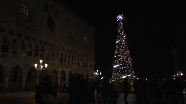 Turistas caminando cerca del árbol de Navidad en Piazza San Marco por la noche — Vídeo de stock