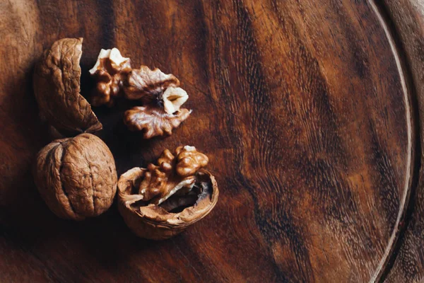 Top view of walnuts on rustic wooden plate