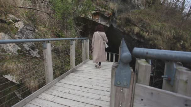 Mulher caminhando em direção à entrada das cavernas Caglieron, Veneto, Itália — Vídeo de Stock