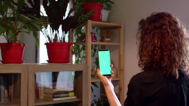 Vrouw op een kamer interactie met een HUD hologram groen scherm — Stockvideo