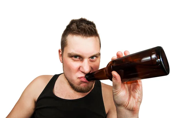 Молодий хлопець алкоголік з головним болем тримає пляшку пива ізольовано на білому тлі — стокове фото