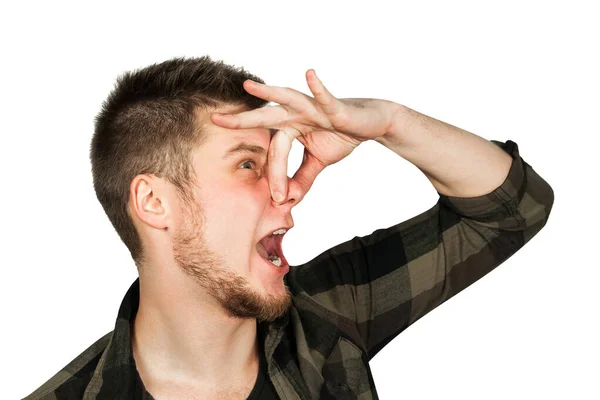 Young guy with beard close nose from a bad smell. Isolated on white background. — Stock Photo, Image